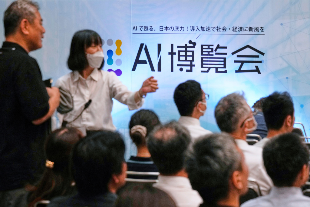 FILE - An usher directs an attendee to a seat for a seminar at a convention titled AI Expo in Tokyo, on Aug. 27, 2025. (AP Photo/Hiro Komae, File)