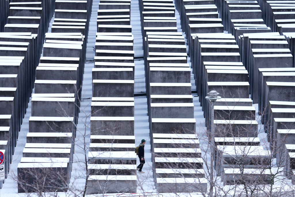 A man walks through the snow covered Holocaust memorial on the International Holocaust Memorial Day in Berlin, Germany, Tuesday, Jan. 27, 2026. (AP Photo/Markus Schreiber)