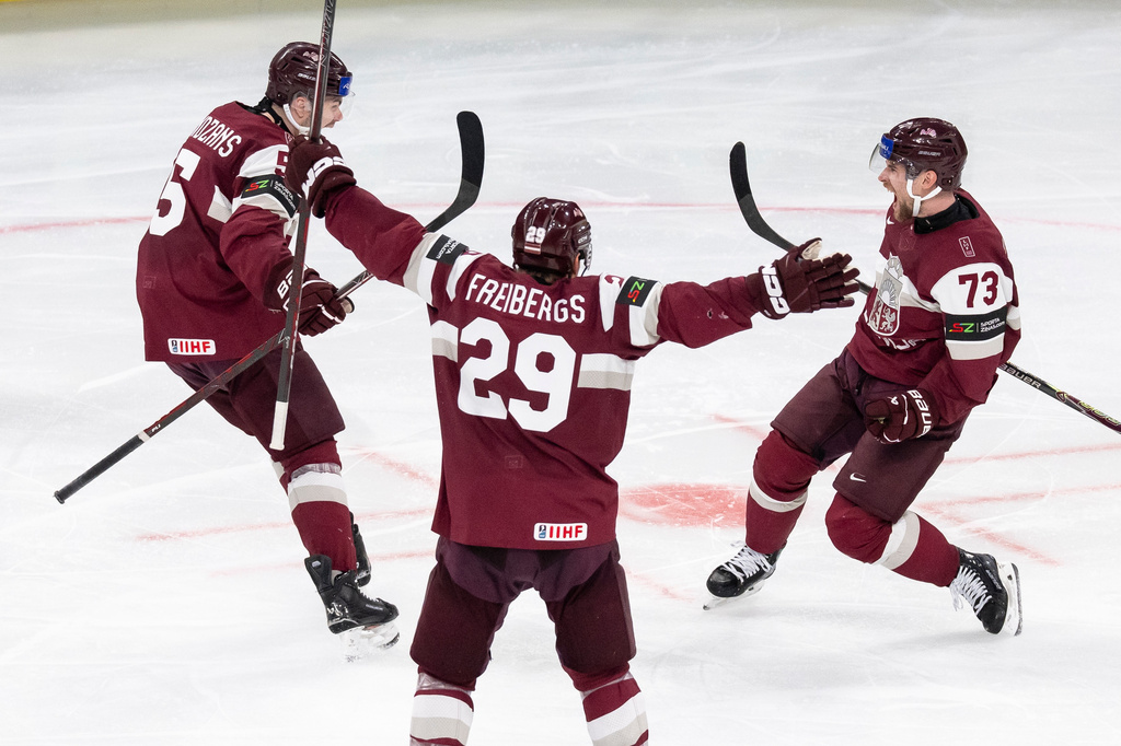 Latvia's Deniss Smirnovs, right, celebrates after scoring his side's second goal during the 2026 IIHF Men's Ice Hockey World Championship preliminary round group A match between Latvia and the United States in Zurich, Switzerland, Saturday, May 23, 2026. (Andreas Becker/Keystone via AP)