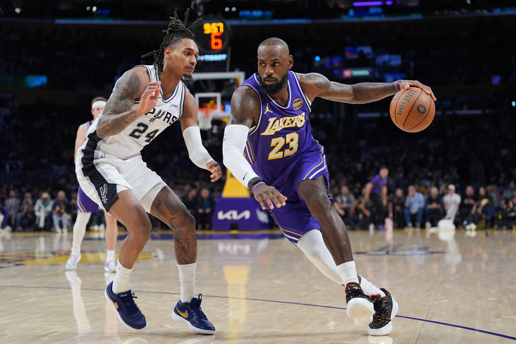 Los Angeles Lakers forward Lebron James (23) drives past San Antonio Spurs guard Devin Vassell (24) during the first half of an NBA Cup basketball game Wednesday, Dec. 10, 2025, in Los Angeles. (AP Photo/Jae C. Hong)