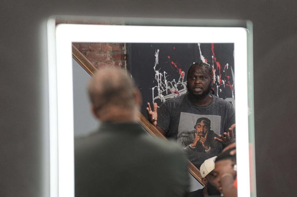 Stanley Thigpen, reflected in a barber shop mirror at Philly Cuts in Philadelphia, speaks, Friday, Aug. 21, 2026, during a discussion facilitated by Win With Black Men. (AP Photo/Matt Rourke)
