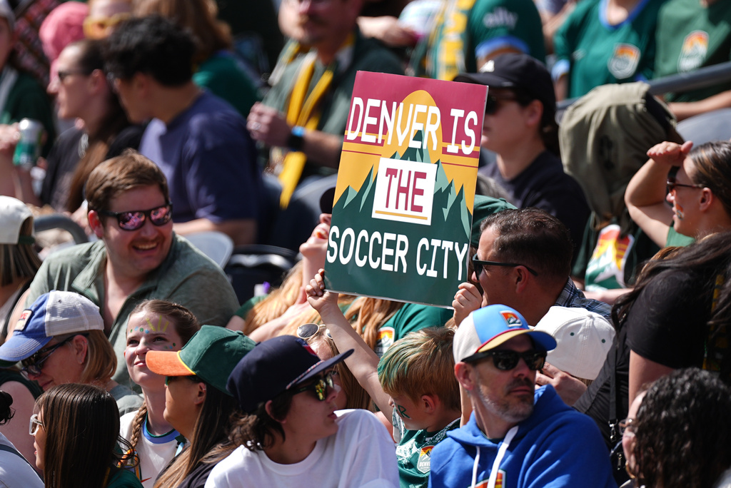 A fan of Denver Summit FC holds up placard in the first half of an NWSL soccer match against the Washington Spirit, Saturday, March 28, 2026, in Denver. (AP Photo/David Zalubowski)