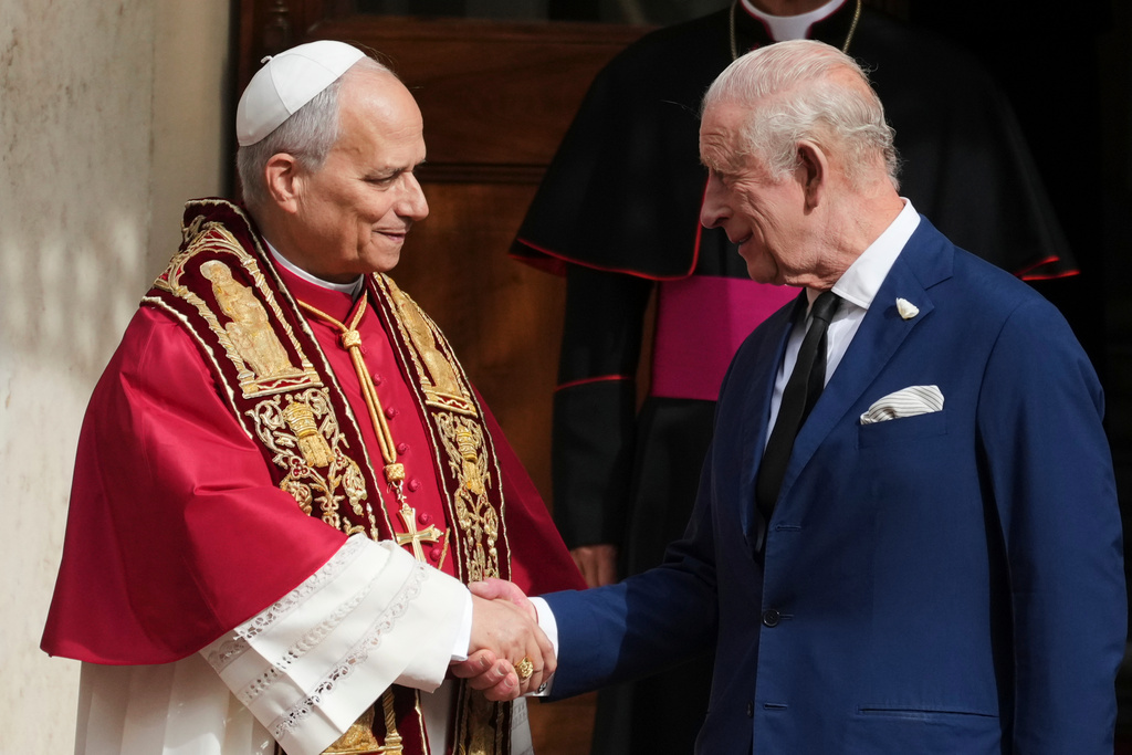 Pope Leo XIV, center, cheers with Britain's King Charles III in the St. Damasus Courtyard at the Vatican after a state visit and pray with him in the Sistine Chapel, Thursday, Oct. 23, 2025. (AP Photo/Andrew Medichini)