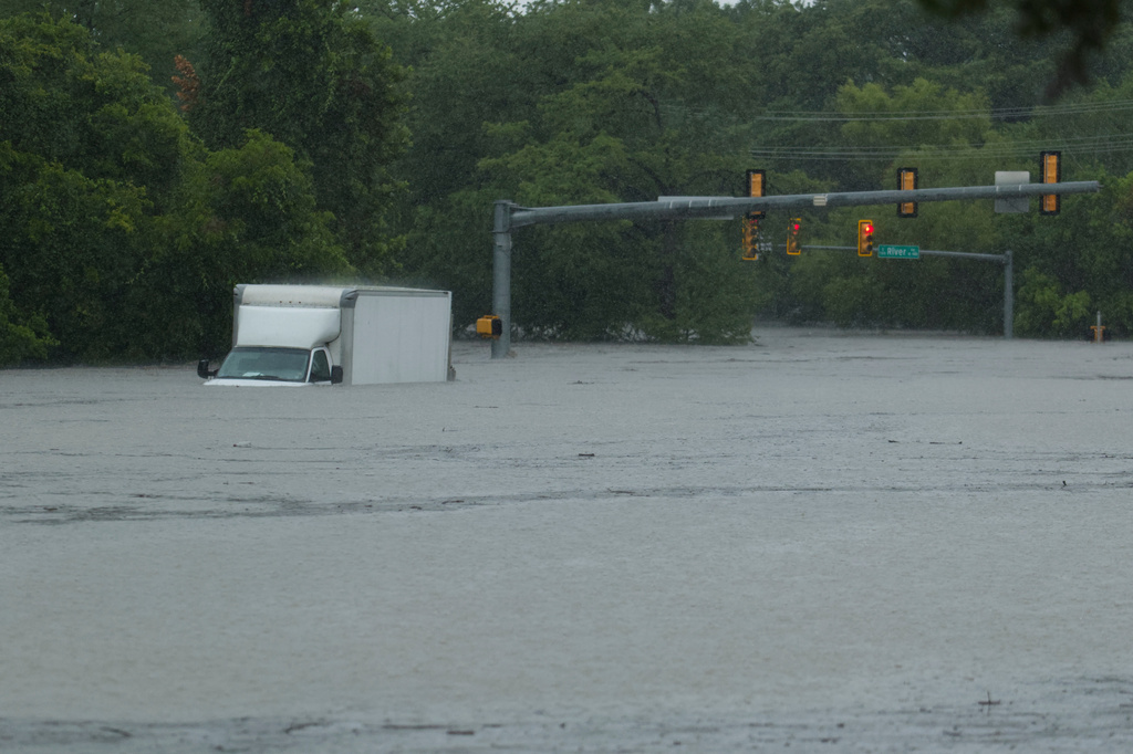 A truck sits submerged in flood waters at an intersection on Wednesday, July 15, 2026, in Boerne, Texas. (AP Photo/Darren Abate)