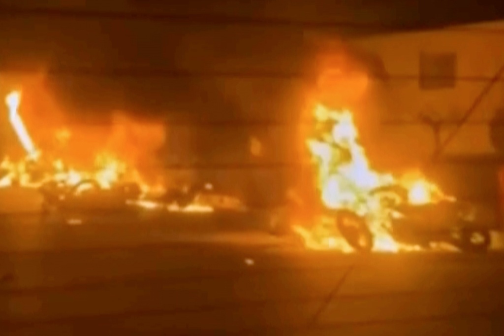 This frame grab from a video released by Iran state TV shows vehicles burning amid night of mass protests in Tehran, Iran, Thursday, Jan. 8, 2026. (Iran state TV via AP)