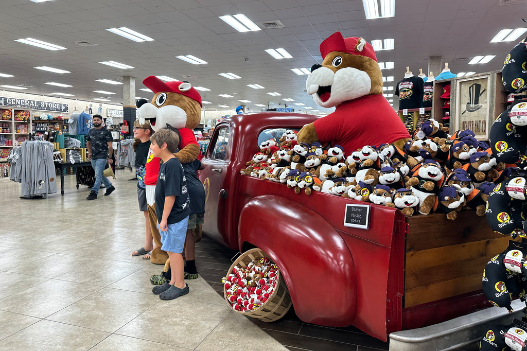 Customers at the Buc-ee's location in Huber Heights, Ohio, pose with the company's mascot on Friday, Aug. 14, 2026. (AP Photo/Julie Carr Smyth)