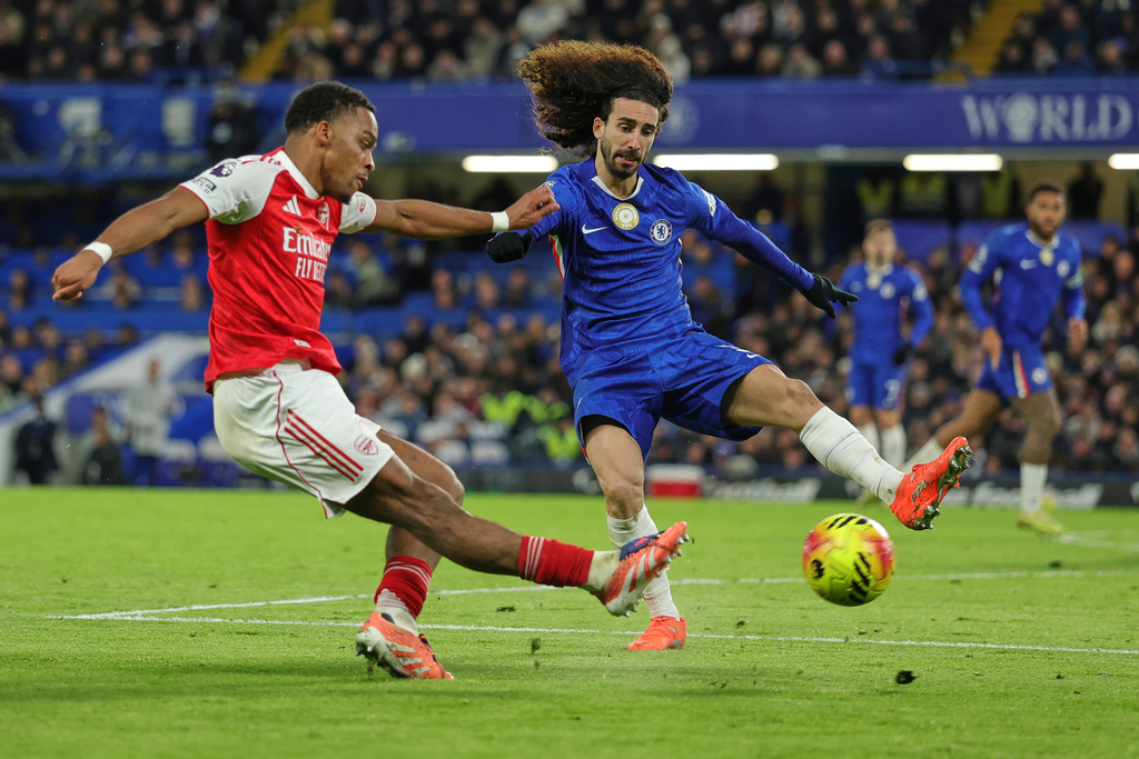 Arsenal's Jurrien Timber, left, kicks the ball ahead of Chelsea's Marc Cucurella during the English Premier League soccer match between Chelsea and Arsenal in London, England, Sunday, Nov. 30, 2025. (AP Photo/Ian Walton)