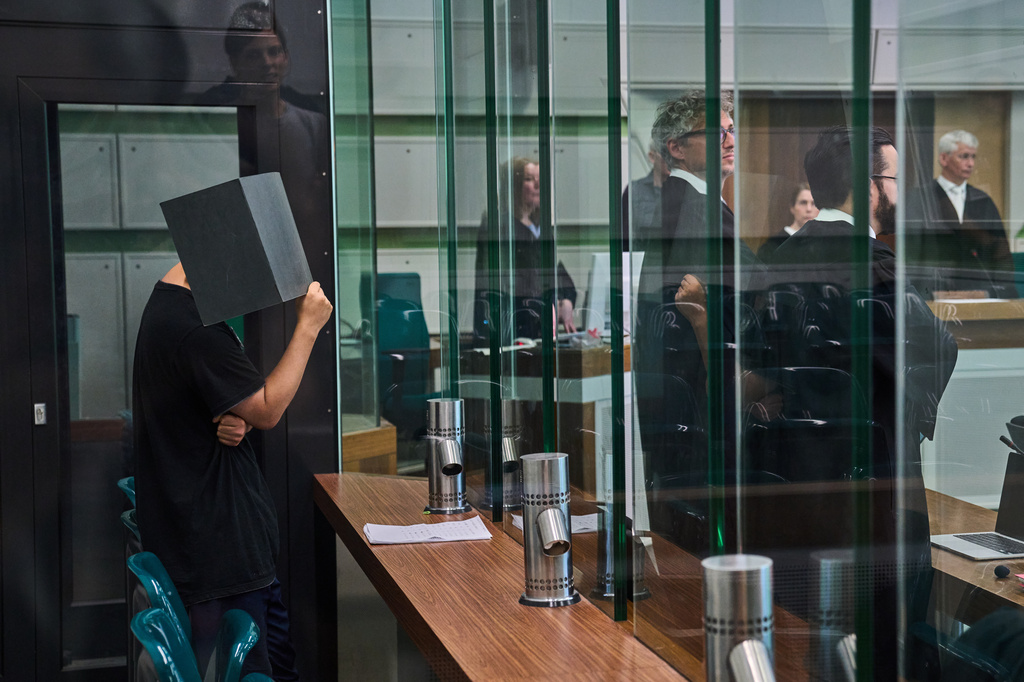 The defendant covering his face in the court during a trial against an online predator network of men accused of using chat groups to share tips on how to drug and rape women, in Berlin, Germany, Wednesday, July 8, 2026. (AP Photo/Ebrahim Noroozi)