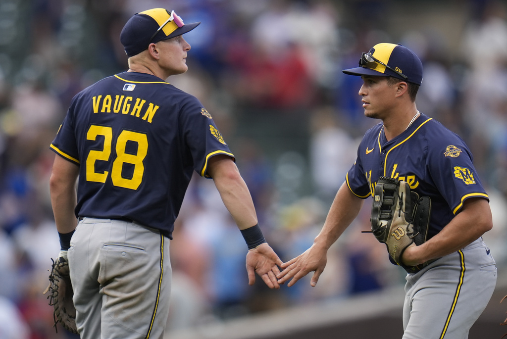 Milwaukee Brewers' Joey Ortiz, right, and Andrew Vaughn (28) celebrate after their team's win over the Chicago Cubs in the first baseball game of a split doubleheader Monday, Aug. 18, 2025, in Chicago. (AP Photo/Erin Hooley)