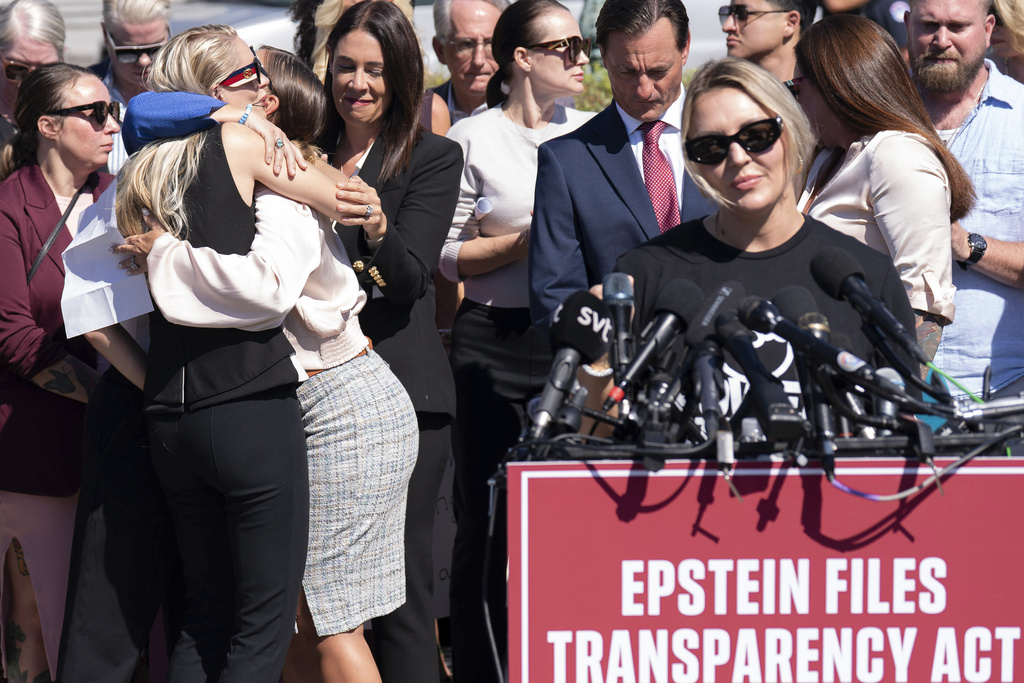 Anouska de Georgiou, left, hugs Marina Lacerda as Courtney Wild, right, speaks during a news conference at the U.S. Capitol, Wednesday, Sept. 3, 2025, in Washington. (AP Photo/Jose Luis Magana)