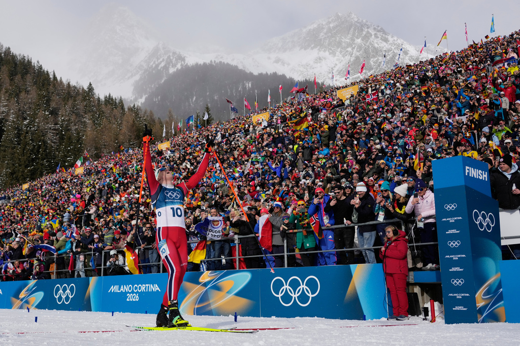 Johannes Dale-Skjevdal, of Norway, crosses the finish line to win gold in the men's 15-kilometer mass start biathlon race at the 2026 Winter Olympics in Anterselva, Italy, Friday, Feb. 20, 2026. (AP Photo/David J. Phillip)