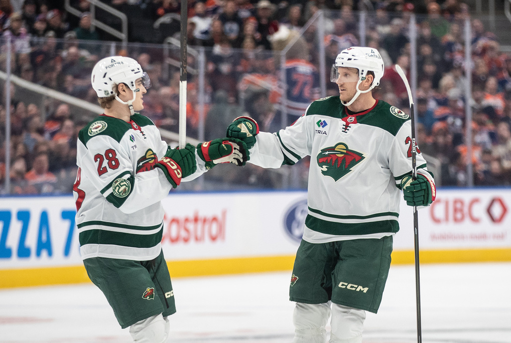 Minnesota Wild's Liam Ohgren (28) and Jonas Brodin (25) celebrate a goal against the Edmonton Oilers during first period NHL action, in Edmonton on Tuesday, Dec. 2, 2025. (Jason Franson/The Canadian Press via AP)