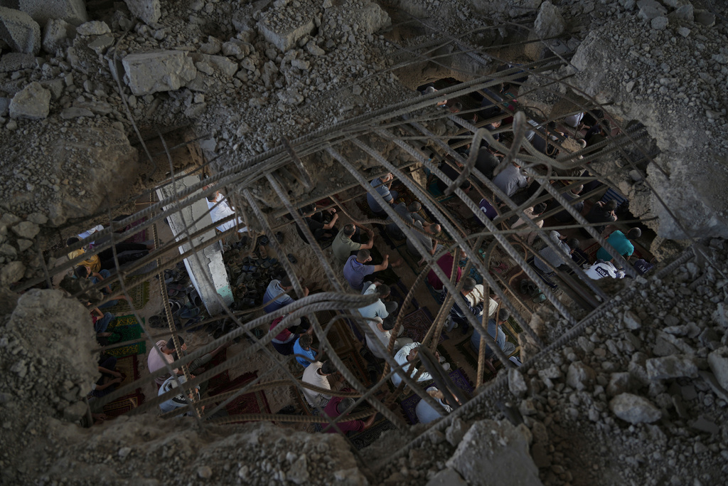 Palestinians gather for Friday prayers amid the rubble of a destroyed building in Khan Younis, in the southern Gaza Strip, Friday, Oct. 17, 2025. (AP Photo/Jehad Alshrafi)