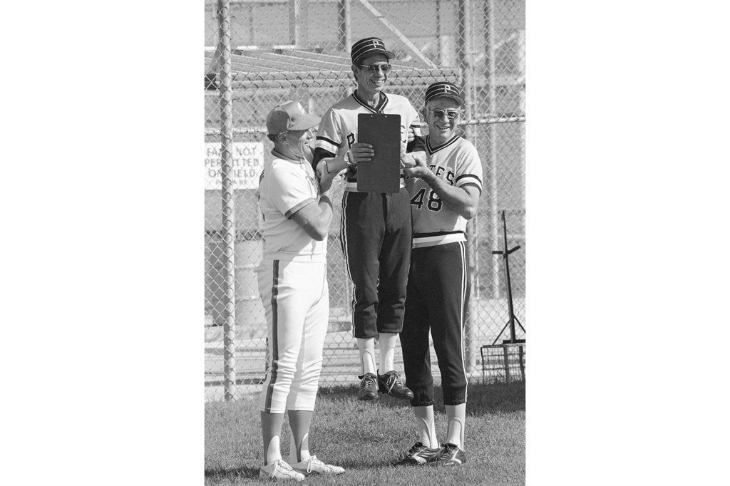 FILE - Pittsburgh Pirates pitching coach Harvey Haddix, center, gets a lift from former teammates Vernon Law, left, now pitching coach for the Seibu Lions, from Japan, and Pirates coach Bob Skinner, right, at the baseball team's spring training complex in Bradenton, Fla., Feb. 23, 1979. (AP Photo/File)