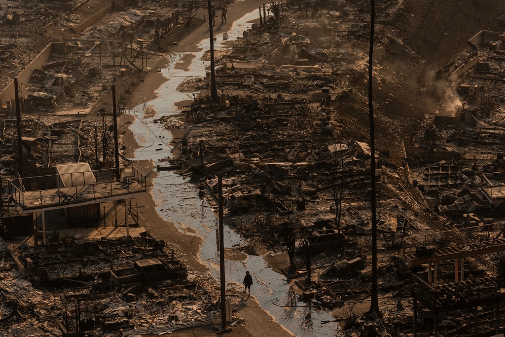 FILE - A person walks amid the destruction left behind by the Palisades Fire in the Pacific Palisades neighborhood of Los Angeles, Jan. 9, 2025. (AP Photo/Jae C. Hong, File)