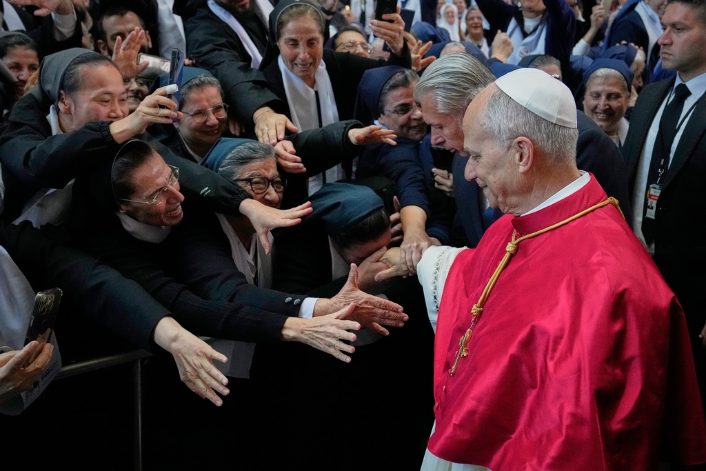 A group of nuns reach out to Pope Leo XIV as he arrives to the Catholic basilica of Harissa, Lebanon Monday, Dec. 1, 2025. (AP Photo/Hussein Malla)