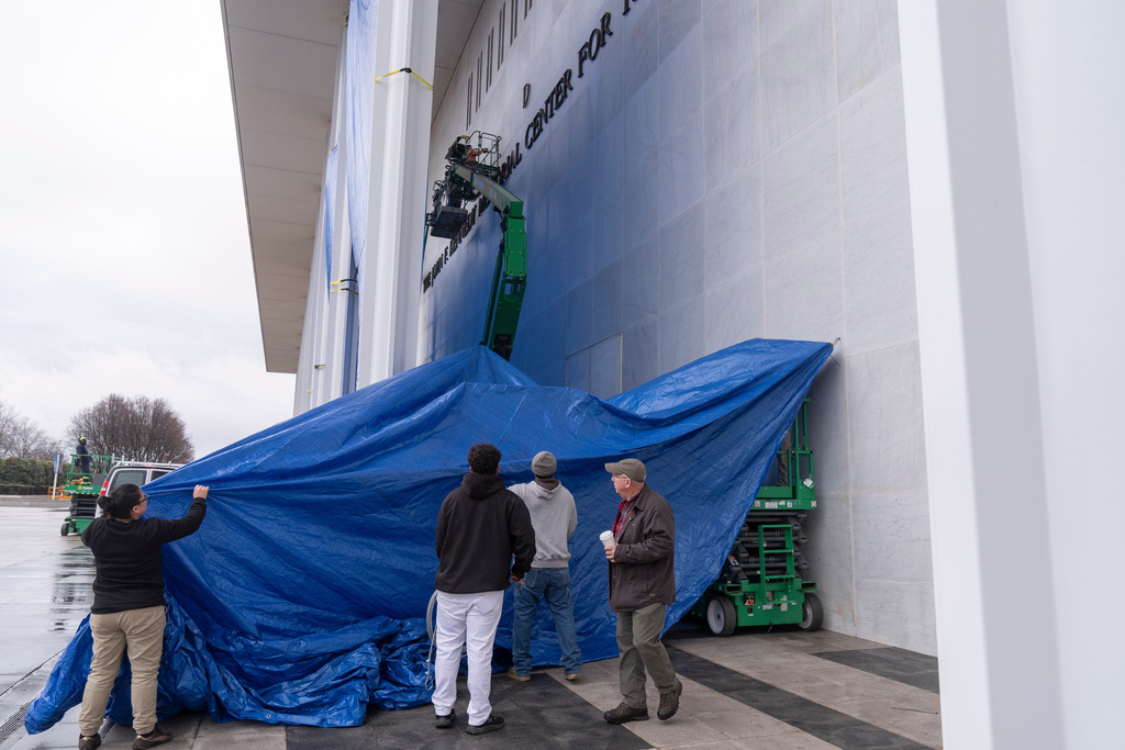 Tarps are installed in front of the sign on the Kennedy Center on Friday, Dec. 19, 2025, in Washington. (AP Photo/Mark Schiefelbein)