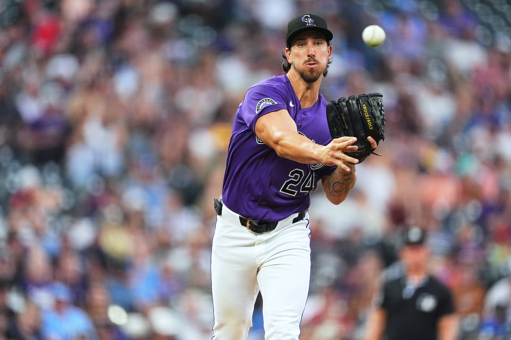 Colorado Rockies starting pitcher Michael Lorenzen turns to make a pickoff throw in the second inning of a baseball game against the Tampa Bay Rays, Monday, Aug. 3, 2026, in Denver. (AP Photo/David Zalubowski)
