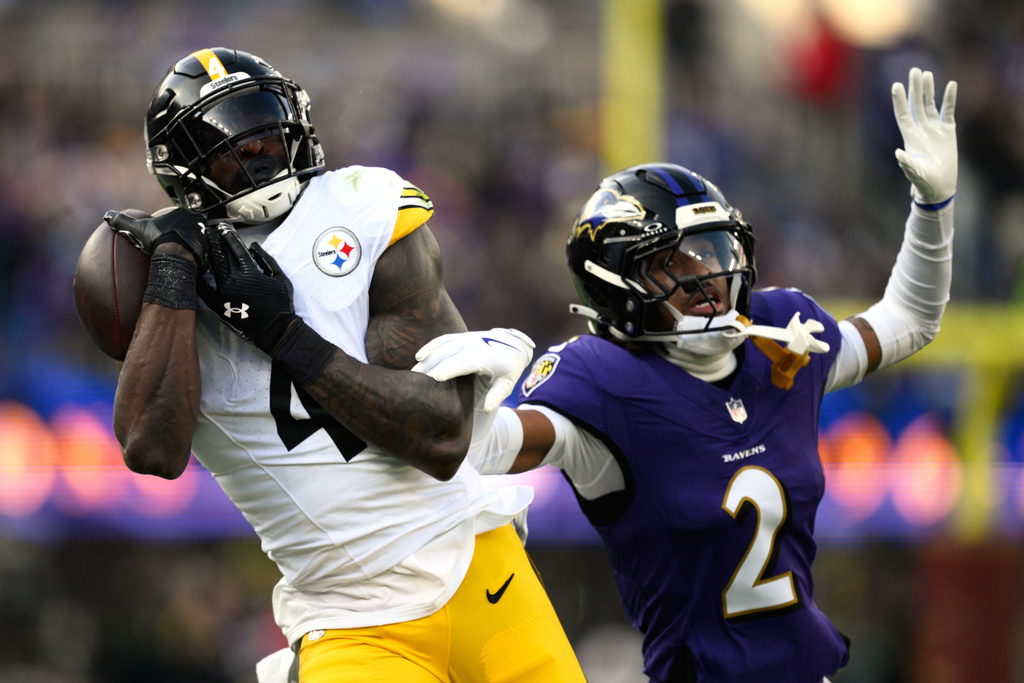 Pittsburgh Steelers wide receiver DK Metcalf (4) catches a pass against Baltimore Ravens cornerback Nate Wiggins (2) during the first half of an NFL football game, Sunday, Dec. 7, 2025, in Baltimore. (AP Photo/Nick Wass)