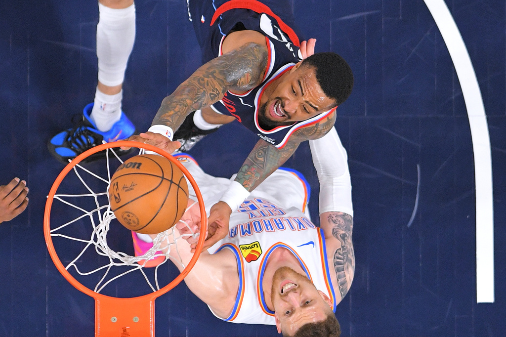 Los Angeles Clippers forward John Collins, top, shoots as Oklahoma City Thunder center Isaiah Hartenstein defends during the first half of an NBA basketball game Wednesday, April 8, 2026, in Inglewood, Calif. (AP Photo/Mark J. Terrill)