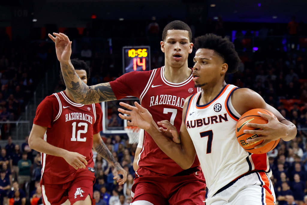 Auburn guard Keyshawn Hall, right, drives toward the basket around Arkansas forward Trevon Brazile, second from right, during the second half of an NCAA college basketball game, Saturday, Jan. 10, 2026, in Auburn, Ala. (AP Photo/Butch Dill)