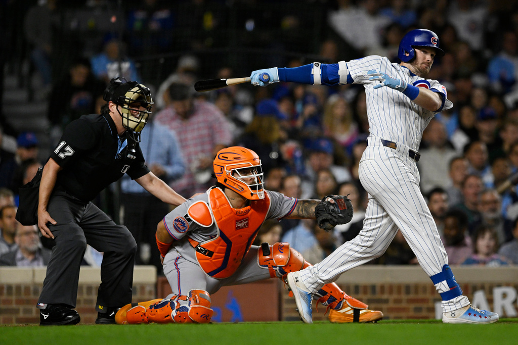 Chicago Cubs' Ian Happ, right, watches his two-RBI double during the third inning of a baseball game against the New York Mets, Wednesday, Sept. 24, 2025, in Chicago. (AP Photo/Paul Beaty)