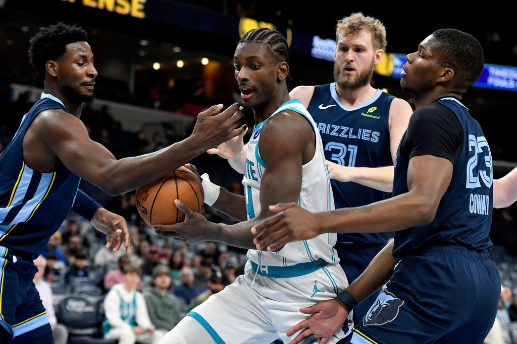 Charlotte Hornets forward Moussa Diabate (14) handles the ball between Memphis Grizzlies forward Jaren Jackson Jr., left, center Jock Landale (31), and forward Cedric Coward (23) in the first half of an NBA basketball game Wednesday, Jan. 28, 2026, in Memphis, Tenn. (AP Photo/Brandon Dill)