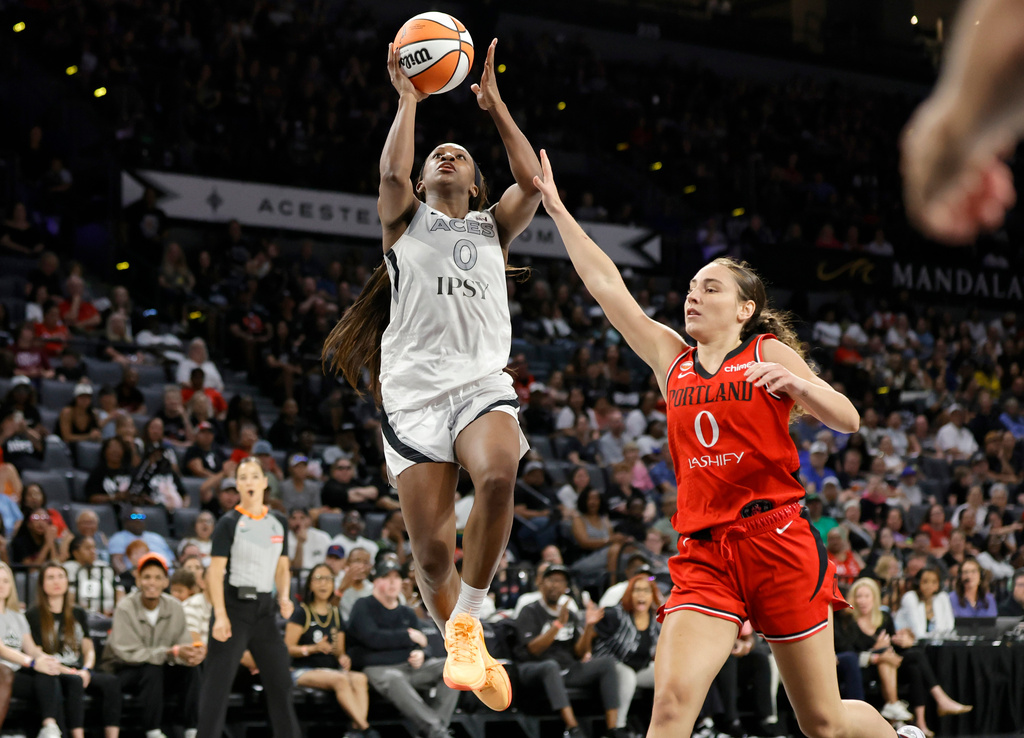 Las Vegas Aces guard Jackie Young (0) shoots a layup past Portland Fire guard Carla Leite (0) during the first half of an WNBA basketball game Tuesday, July 28, 2026, in Las Vegas. (Steve Marcus/Las Vegas Sun via AP)