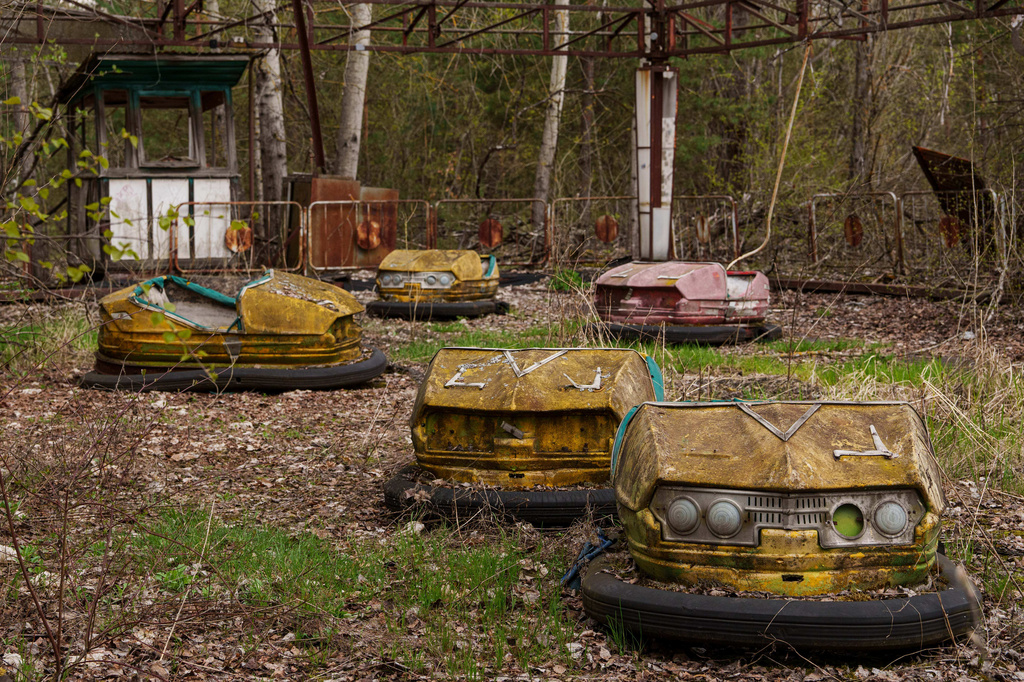 Bumper cars sit idle at an overgrown amusement park in Pripyat, Ukraine, a town left abandoned following the nearby 1986 Chernobyl nuclear disaster, Tuesday, April 21, 2026. (AP Photo/Evgeniy Maloletka)