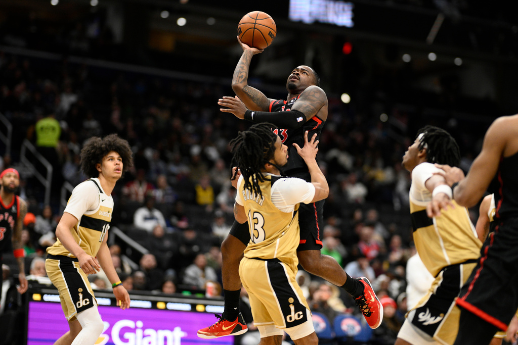 Toronto Raptors guard Jamal Shead, center top, goes to the basket against Washington Wizards guard Sharife Cooper (13) during the first half of an NBA basketball game, Saturday, Feb. 28, 2026, in Washington. (AP Photo/Nick Wass)