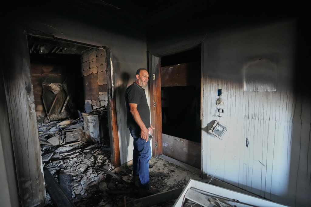 Resident Samih Haidar reacts as he inspects his burned apartment damaged in Israeli strikes in the southern port city of Tyre, Lebanon, Thursday, June 18, 2026. (AP Photo/Hassan Ammar)