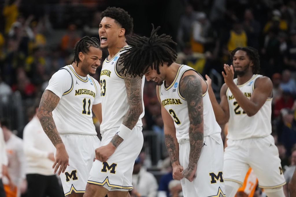 Michigan's Roddy Gayle Jr. (11), Yaxel Lendeborg (23) and Elliot Cadeau (3) celebrate during the first half in the Elite Eight of the NCAA college basketball tournament against Tennessee, Sunday, March 29, 2026, in Chicago. (AP Photo/Erin Hooley)