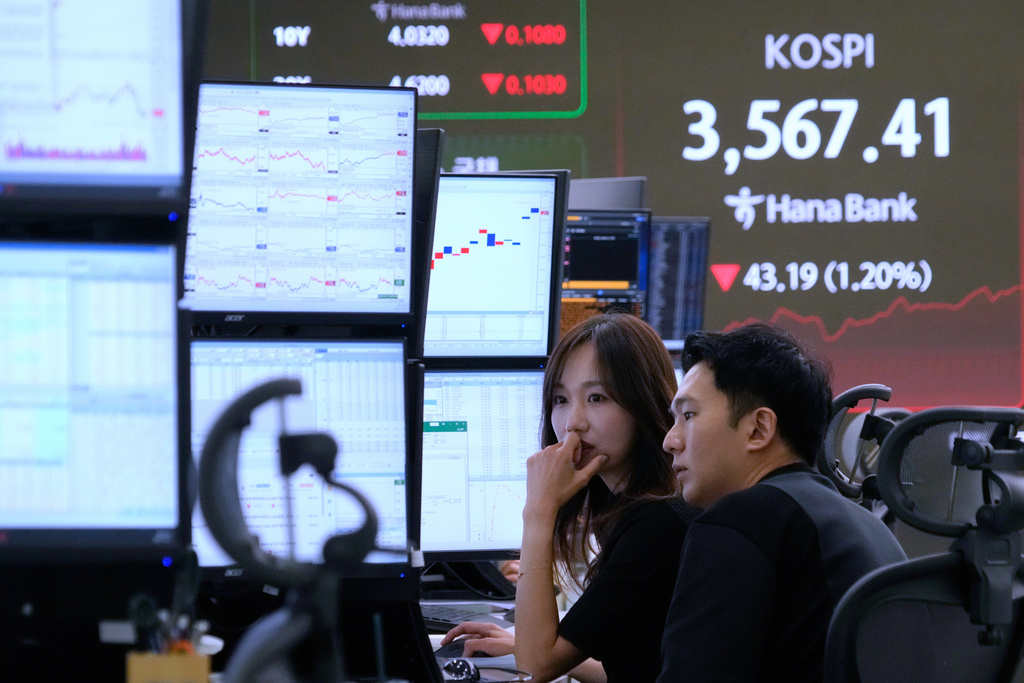 Currency traders watch monitors near a screen showing the Korea Composite Stock Price Index (KOSPI) at the foreign exchange dealing room of the Hana Bank headquarters in Seoul, South Korea, Monday, Oct. 13, 2025. (AP Photo/Ahn Young-joon)