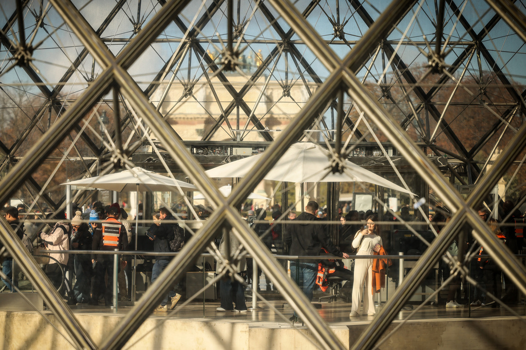 Visitors queue outside the Louvre museum, one week after the robbery, Sunday, Oct. 26, 2025 in Paris. The Paris prosecutor said on Sunday that a number of suspects have been arrested over the theft of crown jewels from Paris' Louvre museum last weekend. (AP Photo/Thomas Padilla)