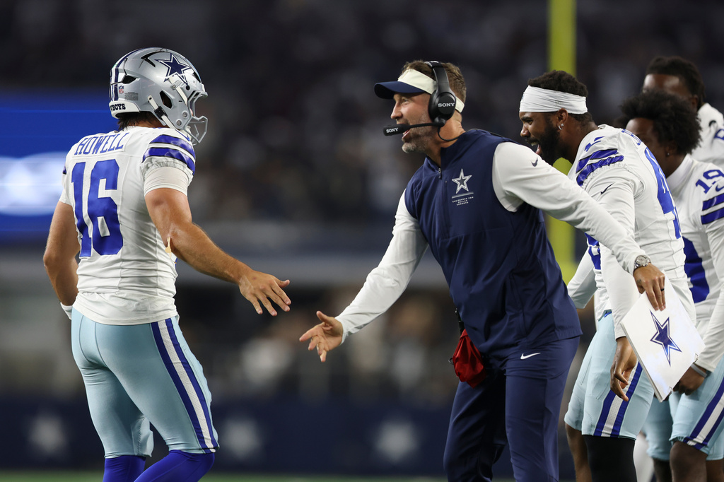 Dallas Cowboys head coach Brian Schottenheimer celebrates with quarterback Sam Howell (16) after a two-point conversion against the New Orleans Saints during the second half of a preseason NFL football game, in Arlington, Texas, Friday, Aug. 28, 2026. (AP Photo/Gareth Patterson)