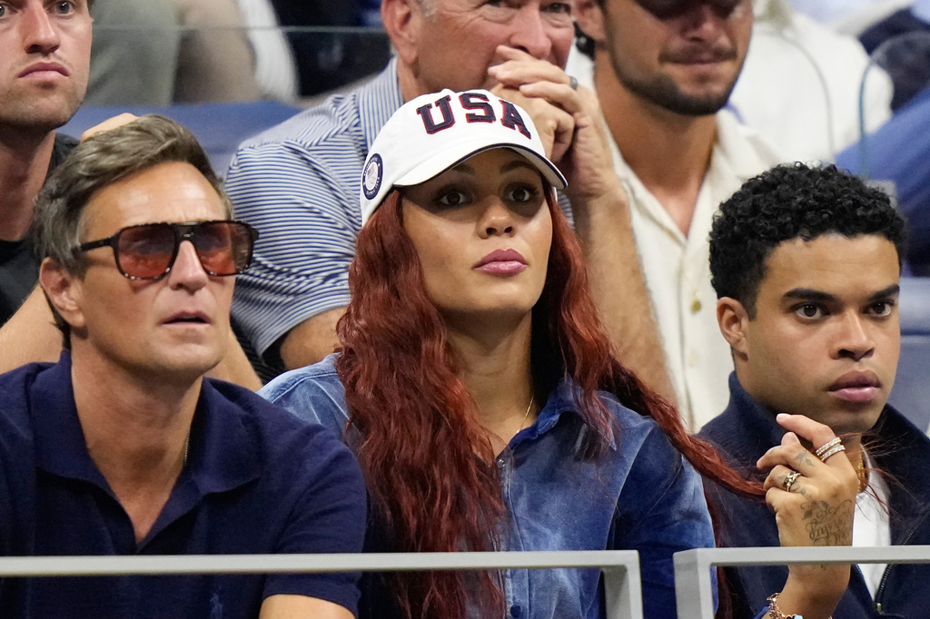 Soccer player Trinity Rodman, center, watches her boyfriend Ben Shelton, of the United States, compete against Frances Tiafoe, of the United States, during the men's singles semifinals of the U.S. Open tennis championships Friday, Sept. 11, 2026, in New York. (AP Photo/Frank Franklin II)