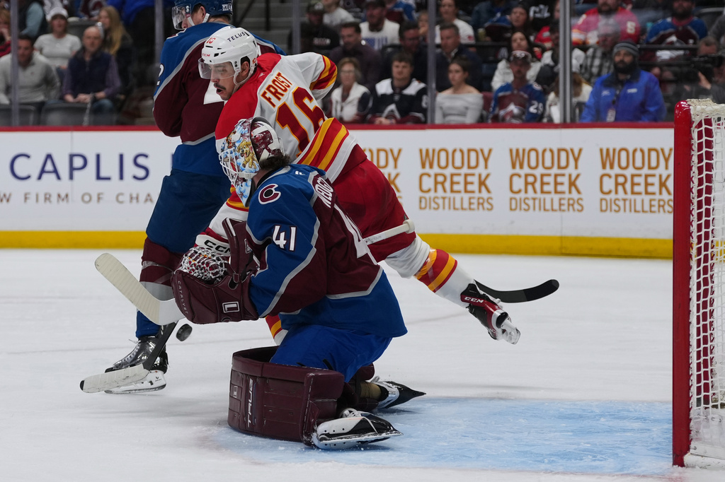 Colorado Avalanche goaltender Scott Wedgewood (41) stops a shot as Calgary Flames center Morgan Frost (16) covers in the second period of an NHL hockey game Monday, March 30, 2026, in Denver. (AP Photo/David Zalubowski)