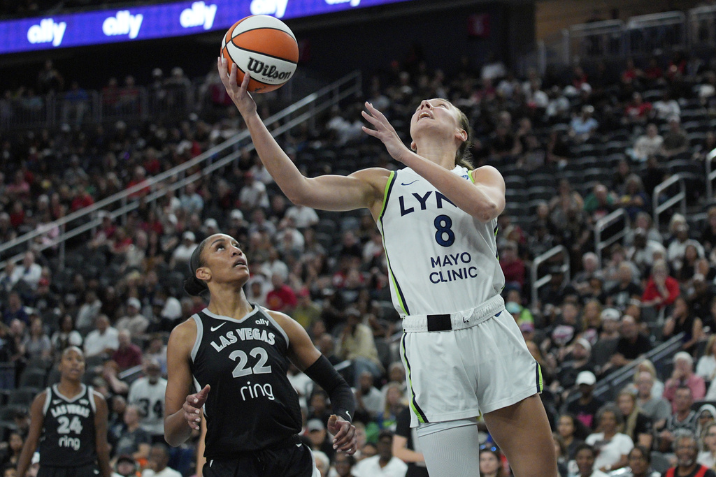 Minnesota Lynx forward Alanna Smith (8) shoots over Las Vegas Aces center A'ja Wilson (22) during the second half of a WNBA basketball game Thursday, Sept. 4, 2025, in Las Vegas. (AP Photo/John Locher)
