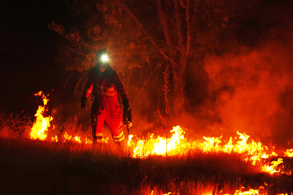 Firefighters use controlled burning to halt a wildfire that continues to spread near Cebreros, Ávila province, Spain, Tuesday, July 28, 2026. (AP Photo/Manu Fernandez)