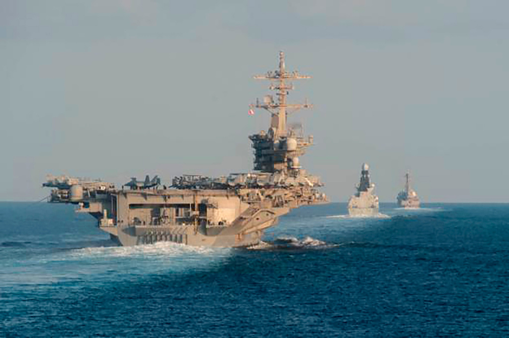 FILE - In this Nov. 19, 2019, photo made available by U.S. Navy, the aircraft carrier USS Abraham Lincoln, left, the air-defense destroyer HMS Defender and the guided-missile destroyer USS Farragut transit the Strait of Hormuz with the guided-missile cruiser USS Leyte Gulf. (Mass Communication Specialist 3rd Class Zachary Pearson/U.S. Navy via AP, File)