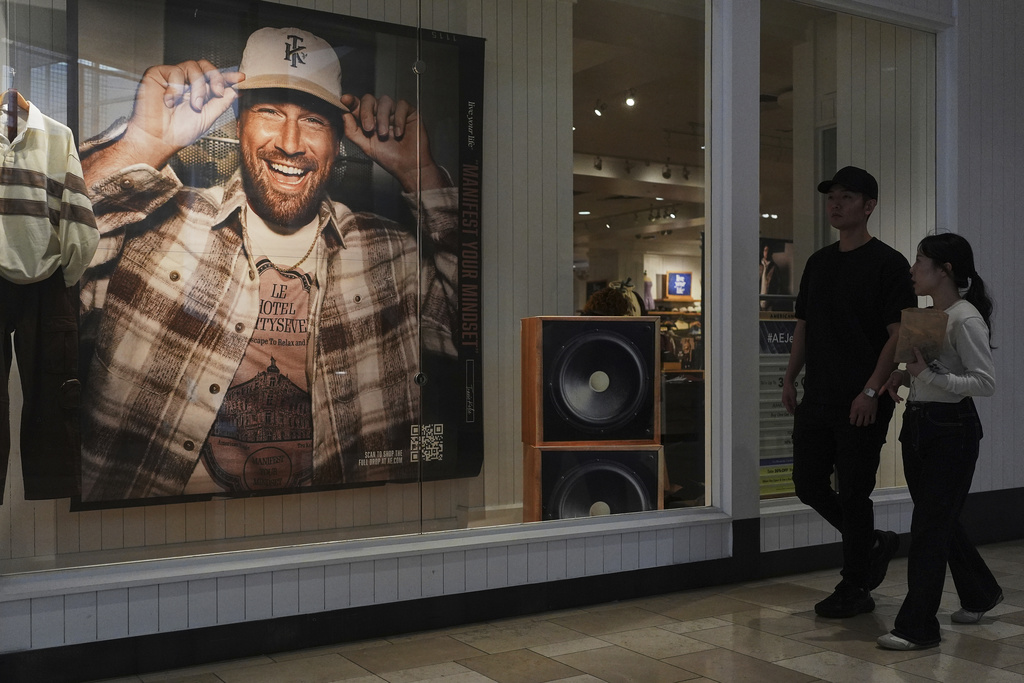 Shoppers walk by an ad featuring Kansas City Chiefs' Travis Kelce outside an American Eagle Outfitters, Thursday, Sept. 4, 2025, in Bellevue, Wash. (AP Photo/Lindsey Wasson)