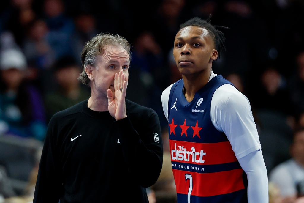 Washington Wizards head coach Brian Keefe, left, talks to guard Bub Carrington during the first half of an NBA basketball game against the Charlotte Hornets in Charlotte, N.C., Saturday, Jan. 24, 2026. (AP Photo/Nell Redmond)