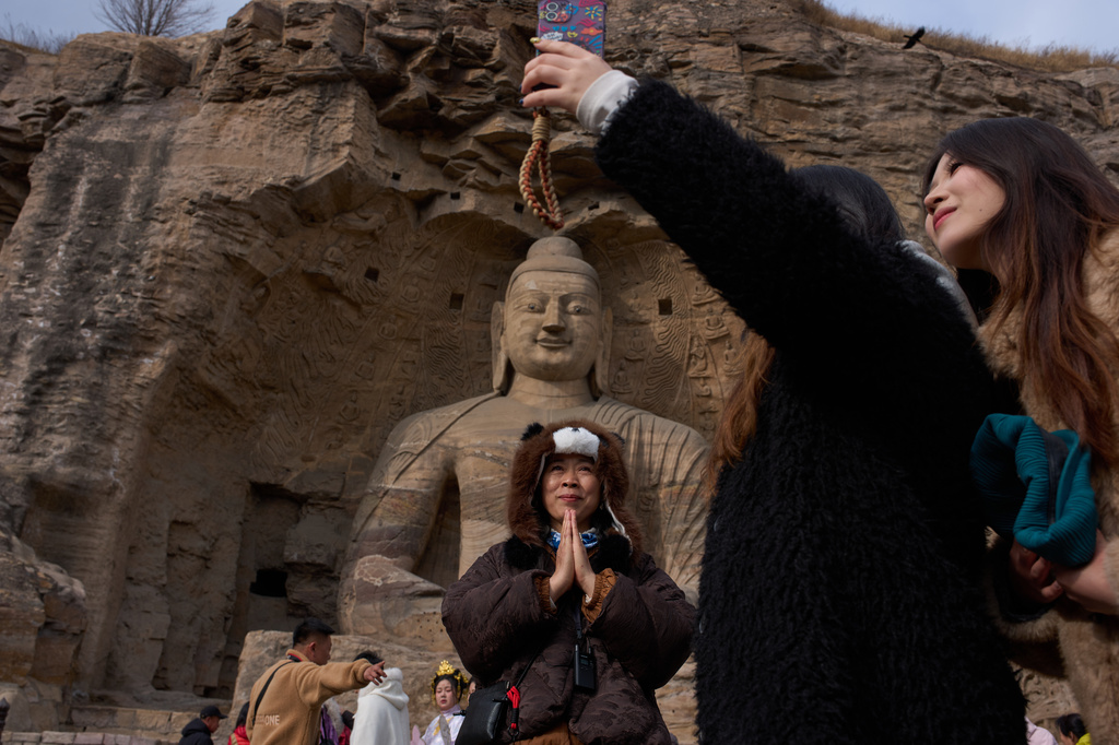 Tourists visit the Yungang Grottoes in Datong, China, Friday, March 13, 2026. (AP Photo/Ng Han Guan)