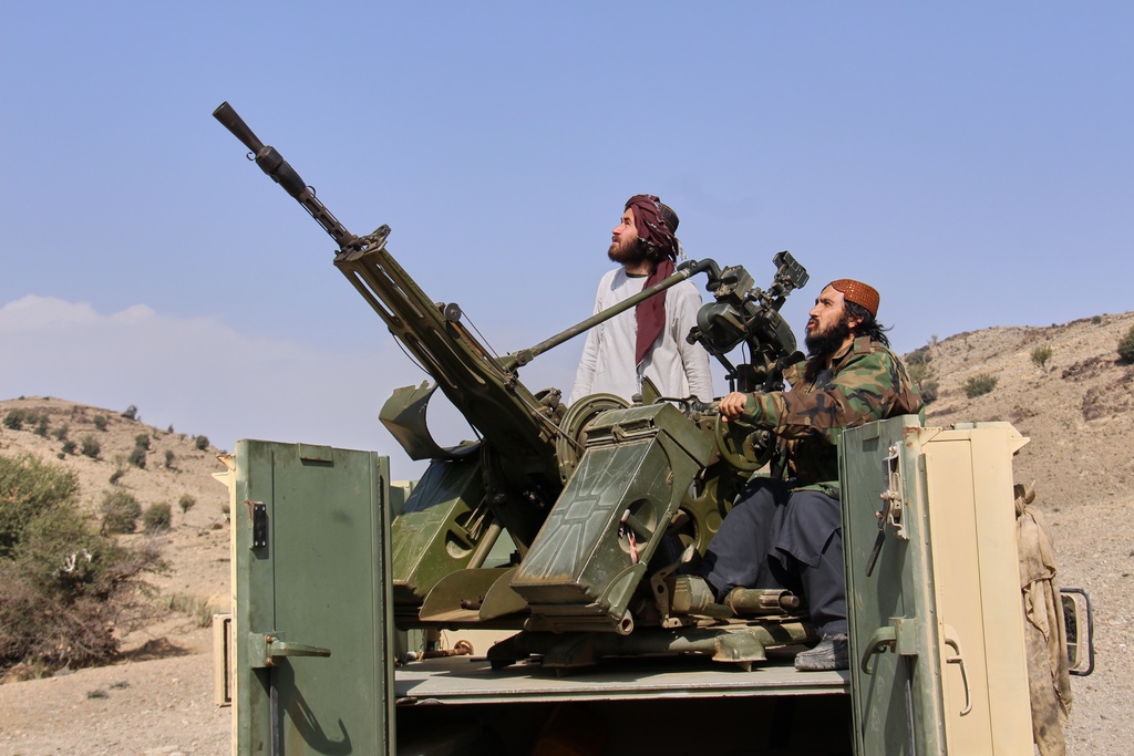 Taliban fighters look up while manning an armed pickup truck at the Afghan side of the Ghulam Khan crossing with Pakistan in Khost province, Afghanistan, Friday, Feb. 27, 2026. (AP Photo/Saifullah Zahir)