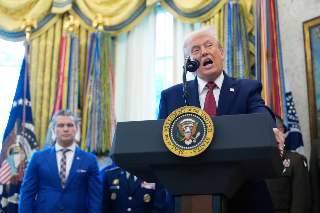 President Donald Trump speaks during a Mexican Border Defense Medal presentation in the Oval Office of the White House, Monday, Dec. 15, 2025, in Washington, as Defense Secretary Pete Hegseth, looks on. (AP Photo/Alex Brandon)
