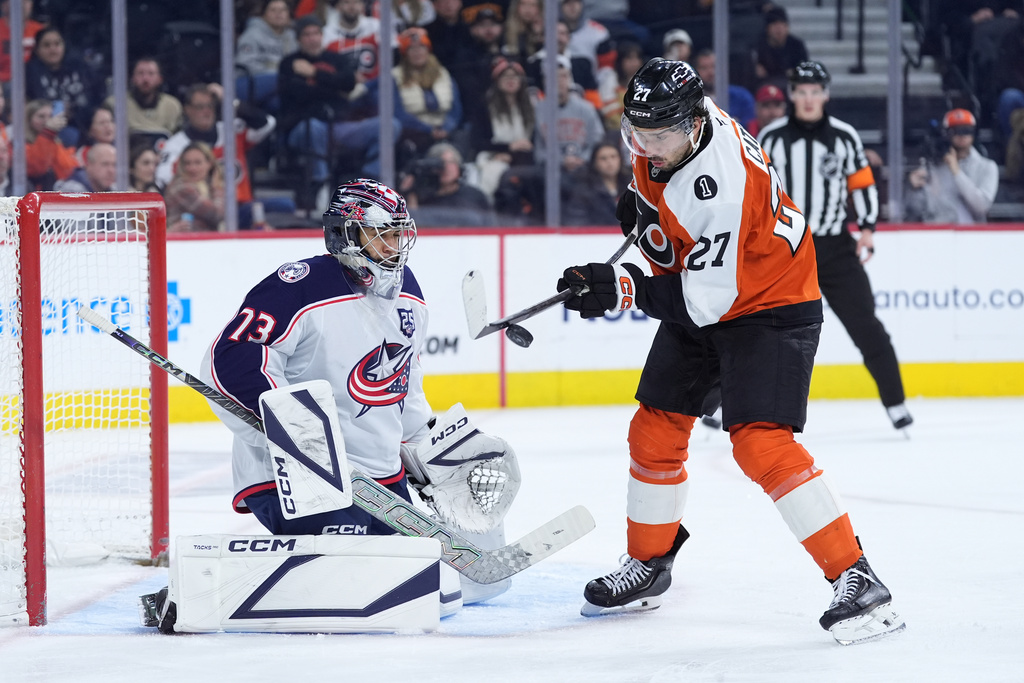 Philadelphia Flyers' Noah Cates, right, tries to get the puck past Columbus Blue Jackets' Jet Greaves during the second period of an NHL hockey game Tuesday, March 24, 2026, in Philadelphia. (AP Photo/Matt Slocum)