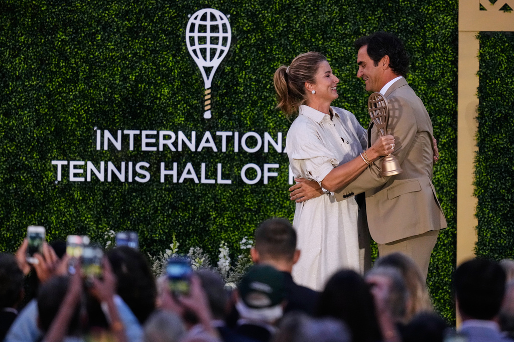Roger Federer is embraced by his wife Mirka during his induction ceremony at the International Tennis Hall of Fame, Saturday, Aug. 29, 2026, in Newport, R.I. (AP Photo/Charles Krupa)