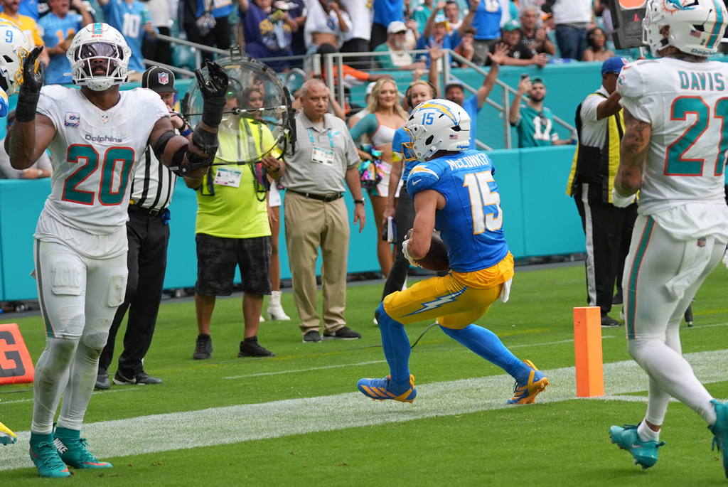 Los Angeles Chargers wide receiver Ladd McConkey (15) scores a touchdown as Miami Dolphins linebacker Jordyn Brooks (20) reacts during the second half of an NFL football game Sunday, Oct. 12, 2025, in Miami Gardens, Fla. (AP Photo/Lynne Sladky)
