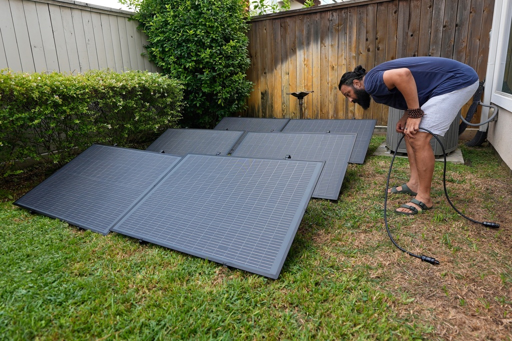 FILE - Bhavin Misra assembles a Craftstrom Solar plug-in kit at his home Aug. 5, 2025, in Houston. (AP Photo/David J. Phillip, File)