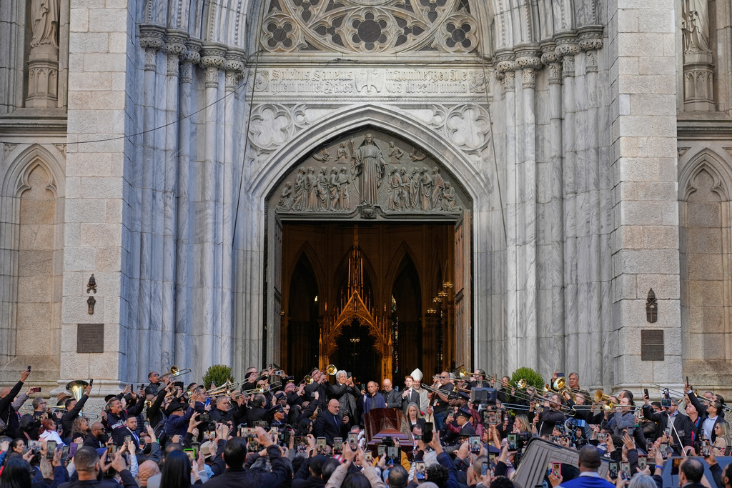 Musicians, primarily trombonists, play music as the body of Willie Colon leaves St. Patrick's Church in New York, Monday, March 9, 2026. (AP Photo/Seth Wenig)